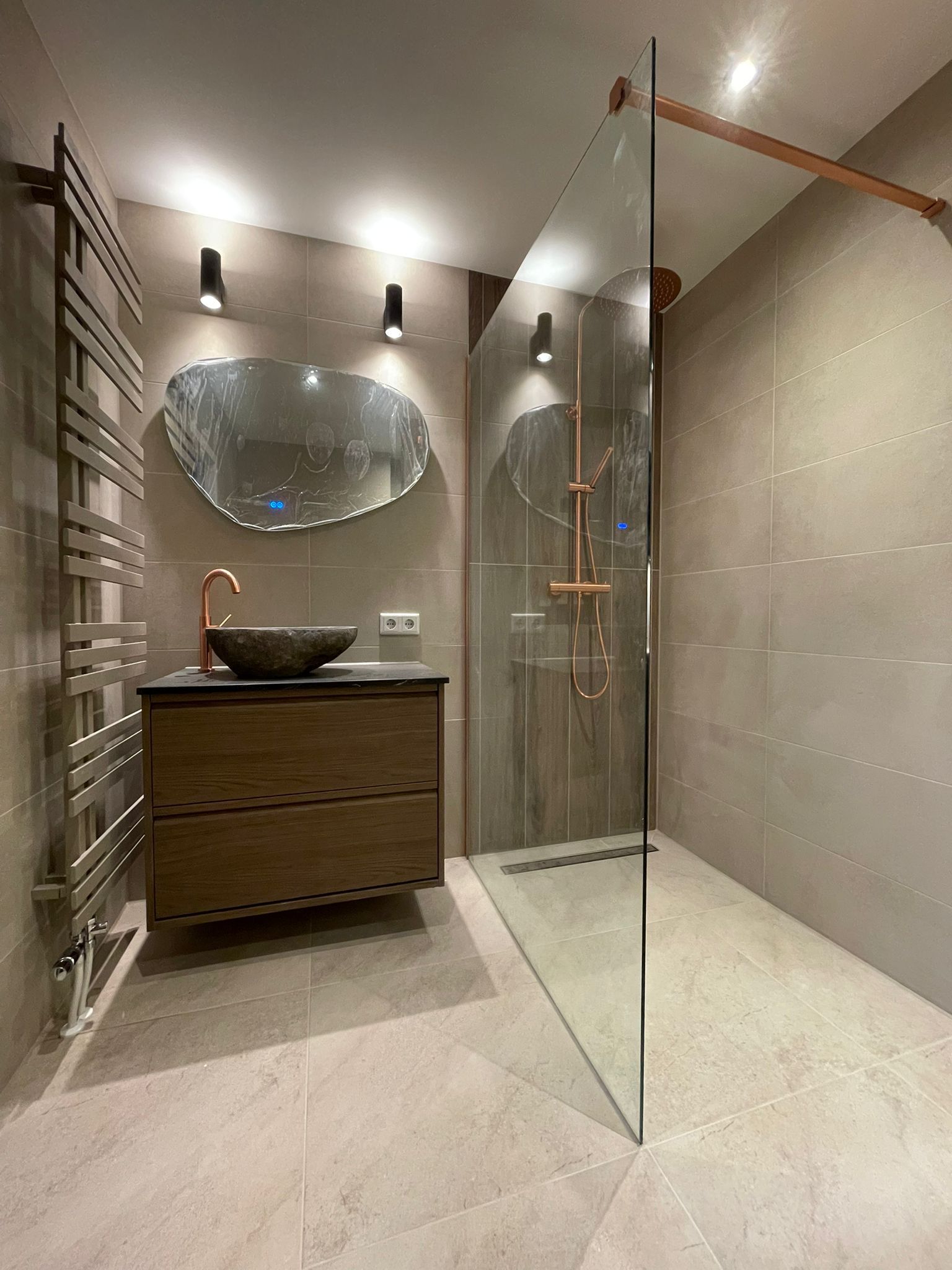 Compleet gerenoveerde badkamer in Eindhoven door Isaacbouw, walk-in douche en op maat vanity met koperen accenten