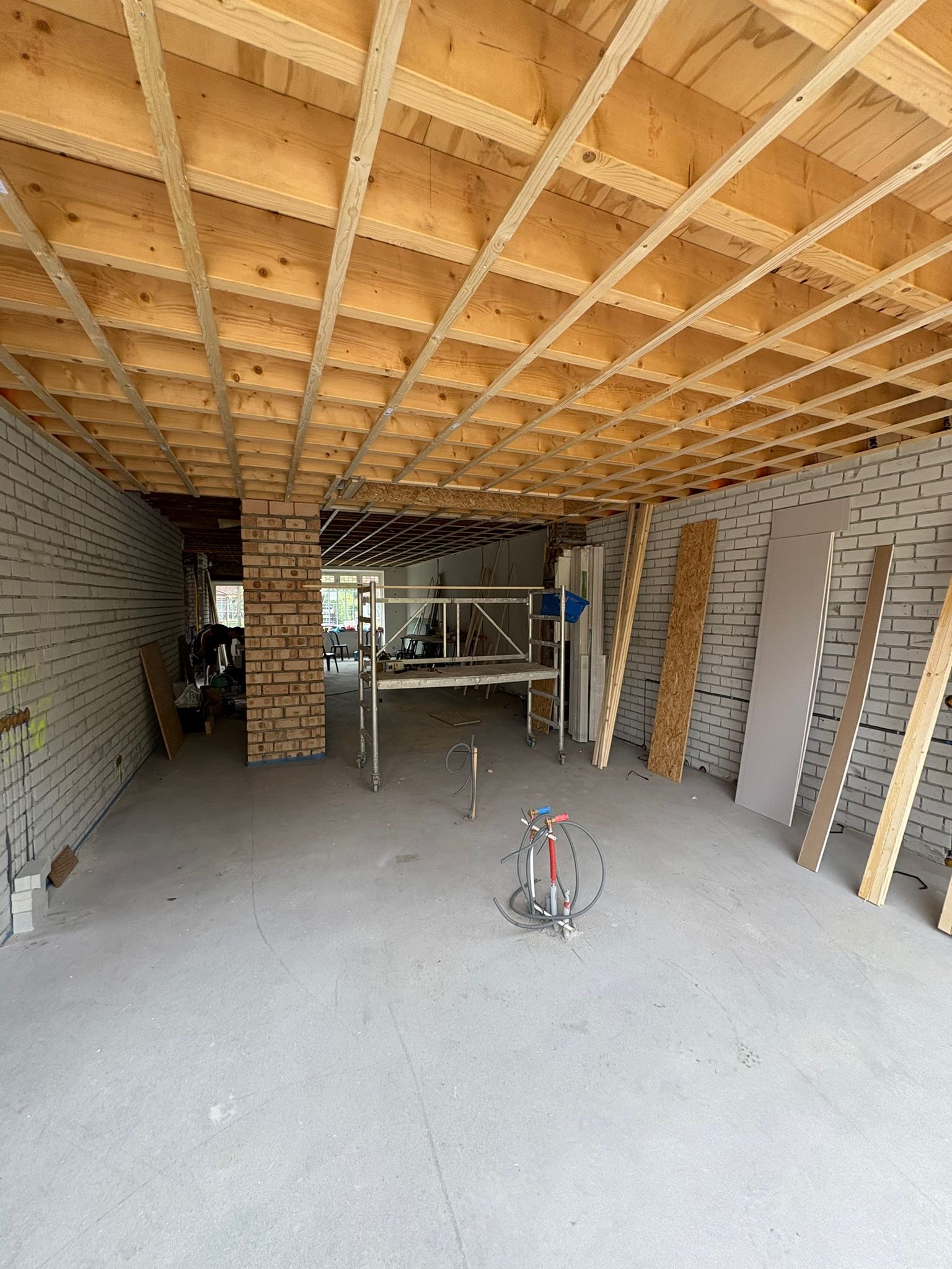 Nieuwe houten dakconstructie boven een ruwe ruimte
