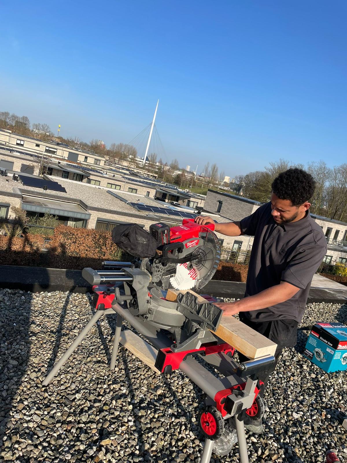 Simeon op locatie aan het zagen op een dak